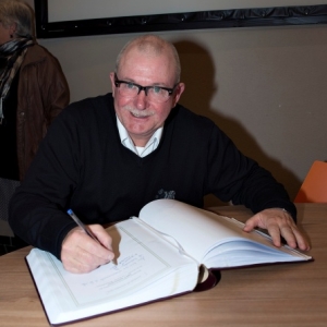 M. Distree, President, signant le Livre d'Or ( Photo de G. Blanchy )