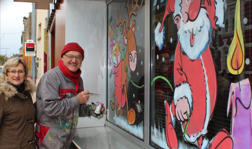 Jean-Marie et Martine Lesage devant une vitrine peinte en France