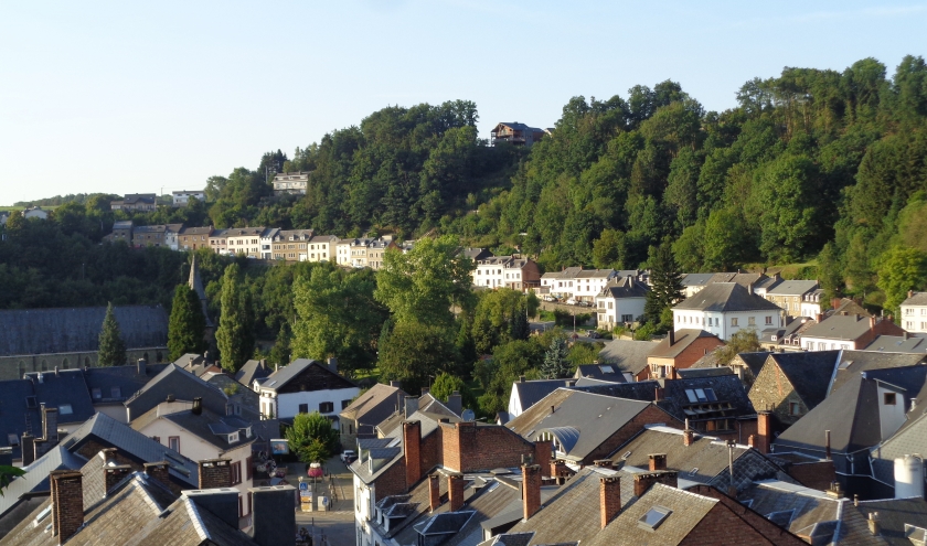 Le Thier des Cochons, au-delà de la crête de feuillus dominant la rue escarpée du Bois des Moines, ancienne route de Liège.