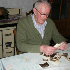 Un ancien Prisonnier de Guerre houffalois regarde les photos de ses souvenirs