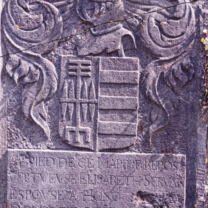 Une pierre tombale scellée dans le mur d'enceinte de l'église